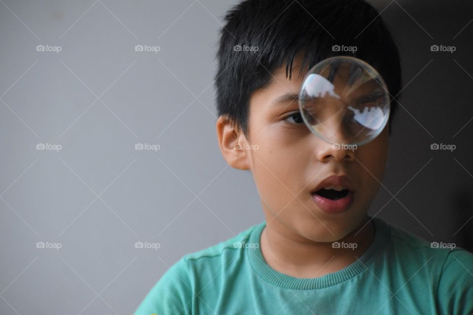 soap bubble in front of eyes of a boy