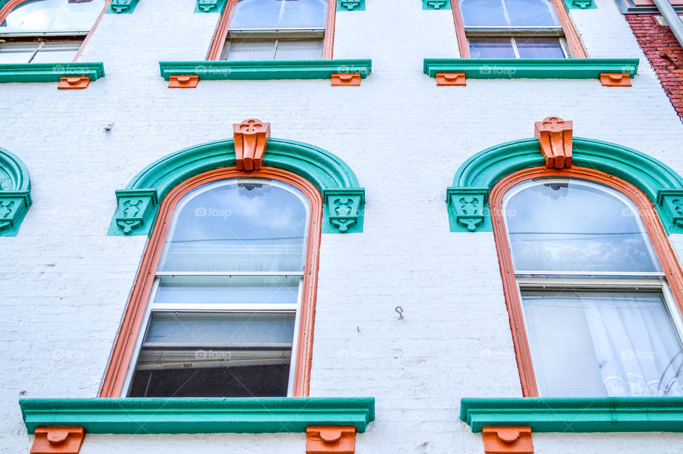 Upward view of old architectural windows on the side of a building in the city