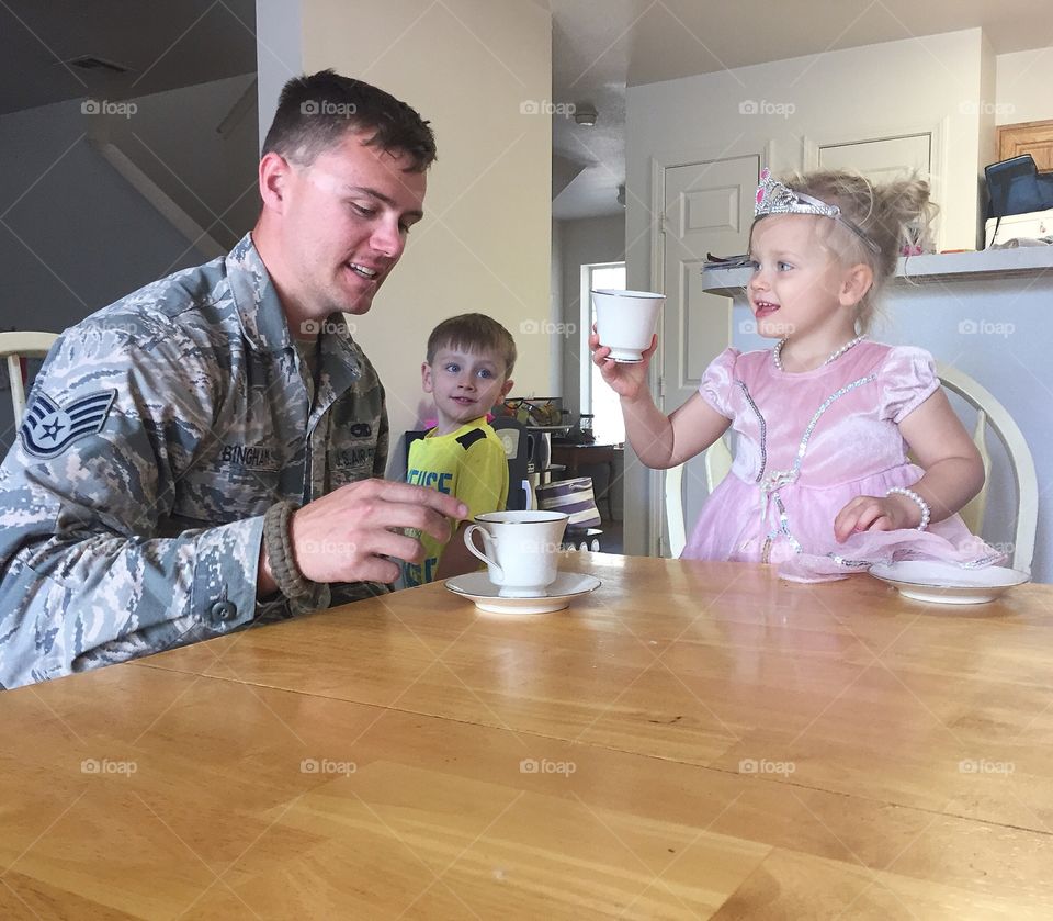 Father drinking coffee with children