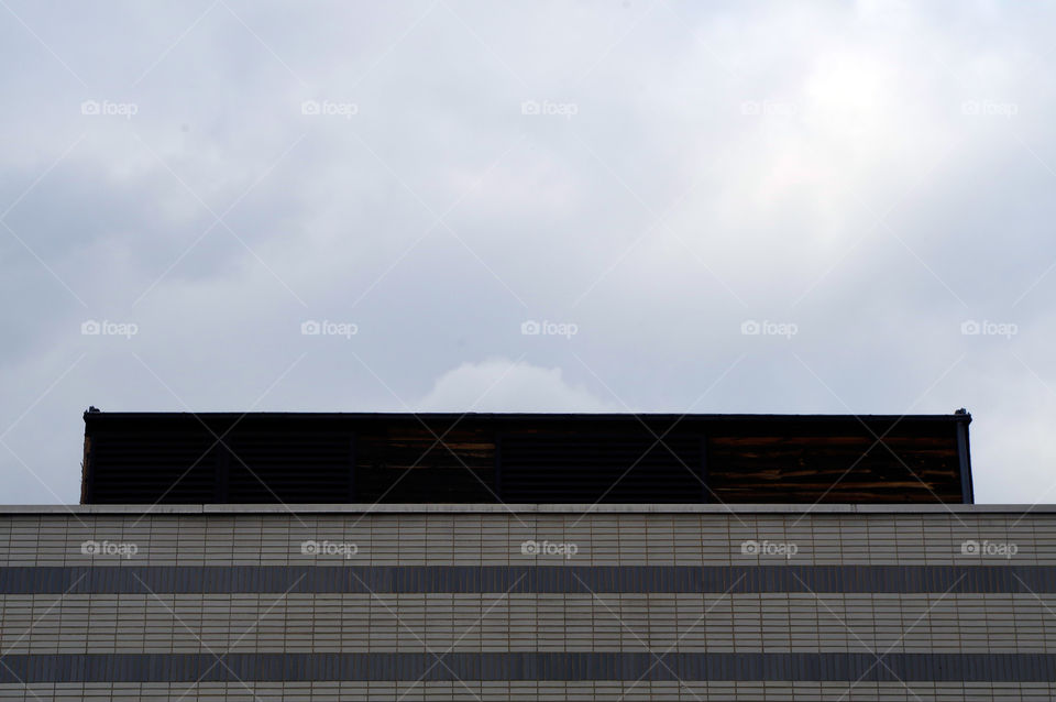 Low angle view of building exterior against cloudy sky in Berlin, Germany.