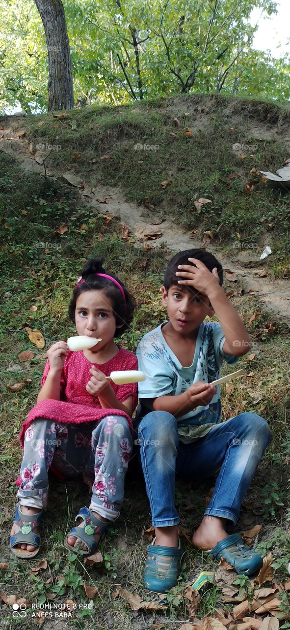 Beatiful & Innocent Children of a rural area enjoying local Ice Creams  in very Hot mid Summer season in Kashmir Valley  J&K  India....