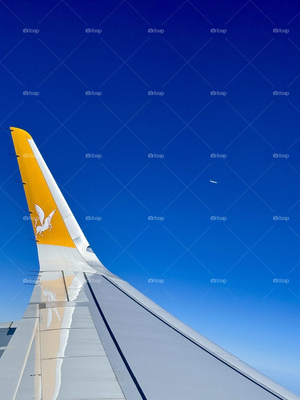 Close-up of the wing of the plane. A plane flying nearby in the sky