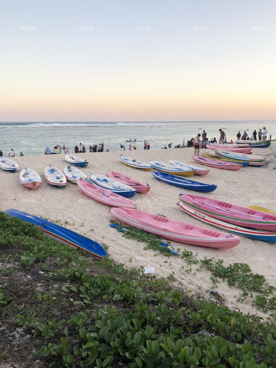 Pink and blue, beach canoes and kayaks at sunset. Portrait style. Taken August 2018.