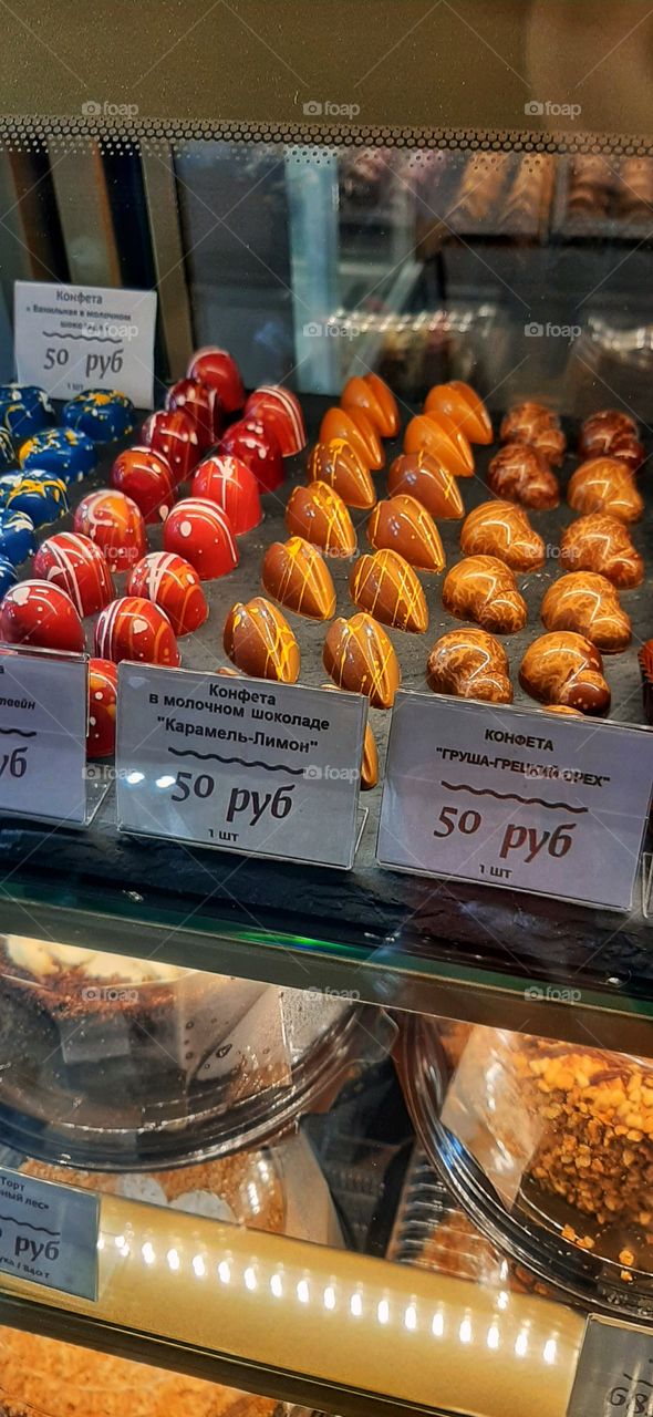 шоколадные конфеты ручной работы на витрине магазина