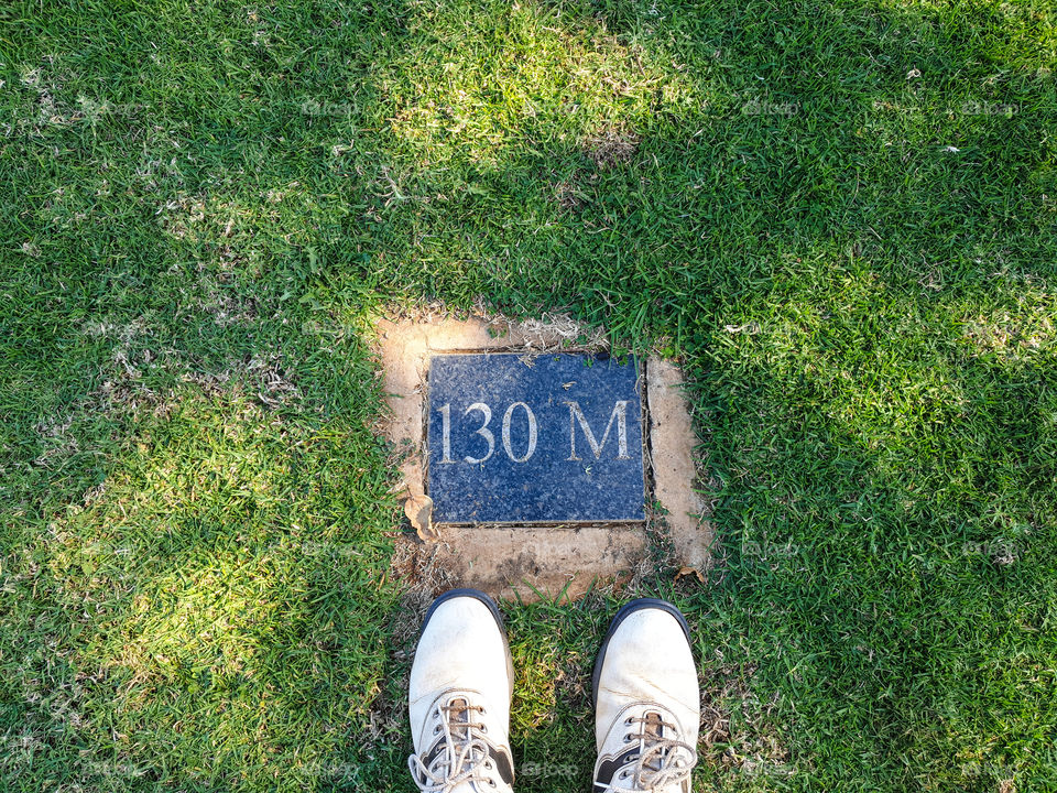 130 meter mark with golf shoes sticking out