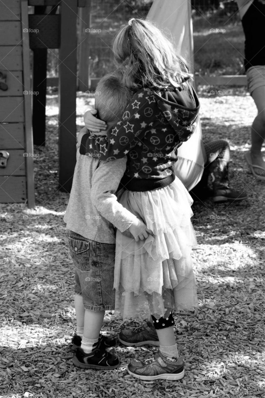 children hugging black and white