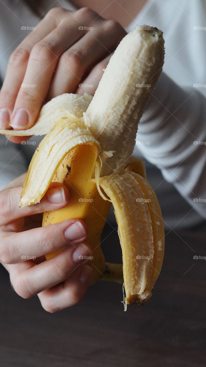 A woman peeling off banana