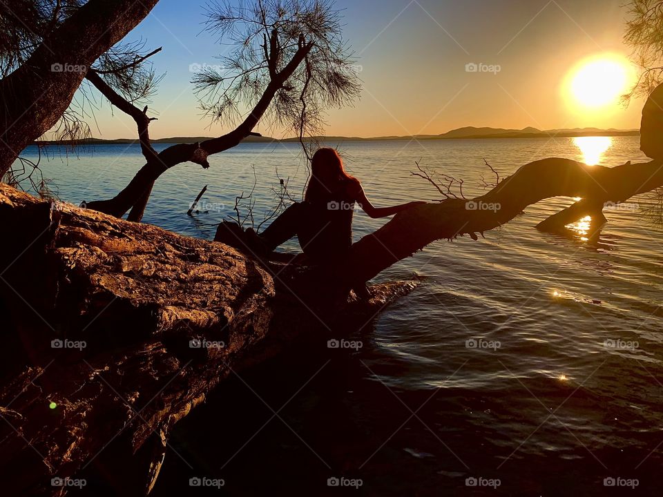 Australian Girl Relaxing Near The Water Whilst The Sunsets In Australia 
