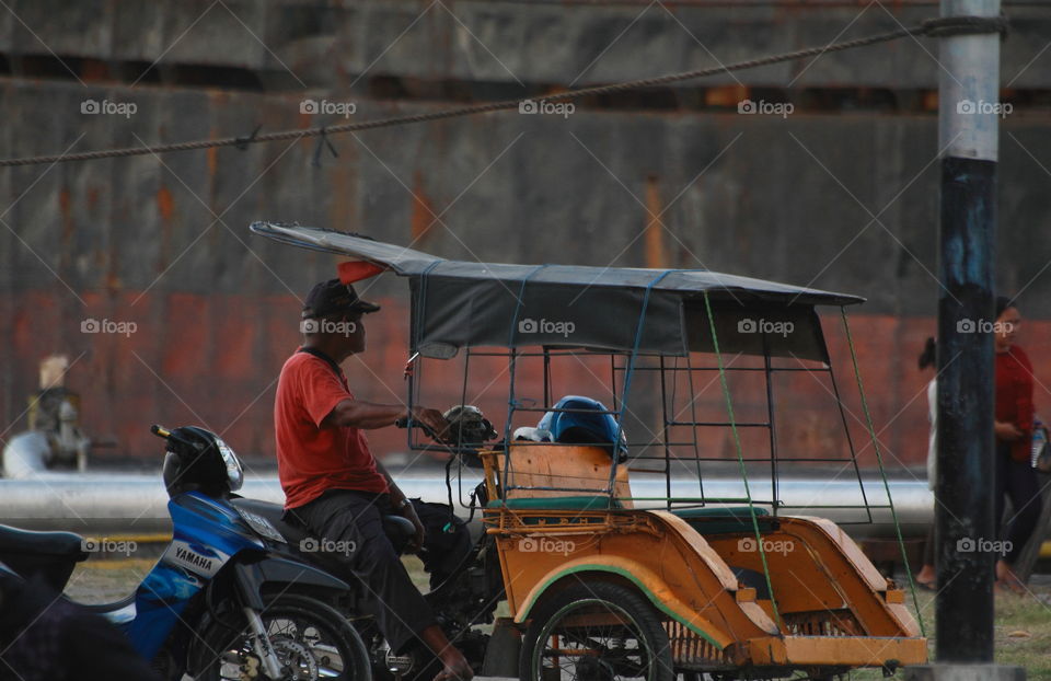 Waiting for passenger. A person wait the passenger interest for the long times at the harbour. What model role transport for citizen to call for " becak motor " ?