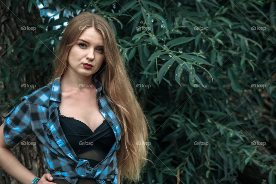 A girl with blond hair in a plaid shirt and short denim shorts on a background of trees and nature,
Girl, woman, man, people, blonde, blonde hair, checkered shirt, shorts shorts, denim shorts, forest, nature, trees, grass, feelings, emotions, tenderness, love, lifestyle, lifestyle, recreation