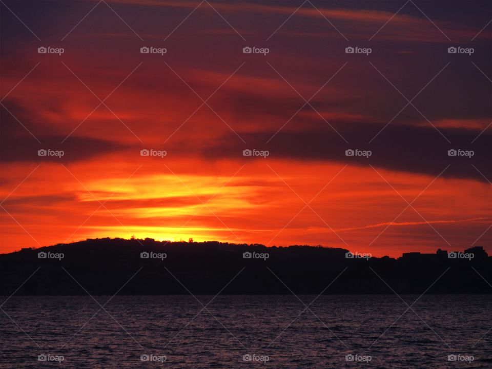 Sun goes down behind the Bacoli hill.  ( Italy ).