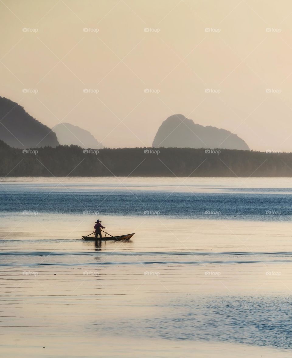 Local life of Thai fisherman use a small net to catch fish in beautiful morning scene