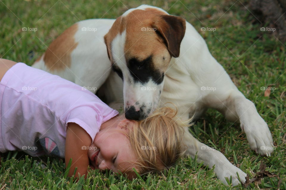 Girl playing on grass with dog