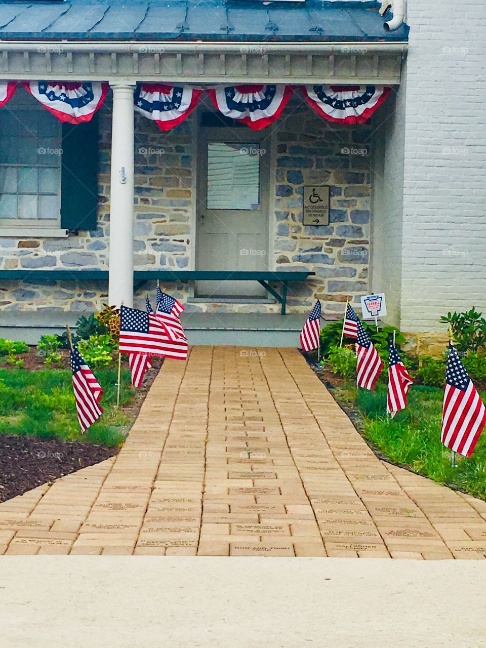 Stone house and walk way with American flags