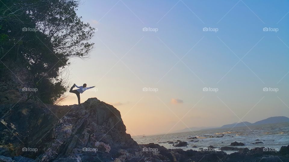 Amateur yoga pose on a cliff