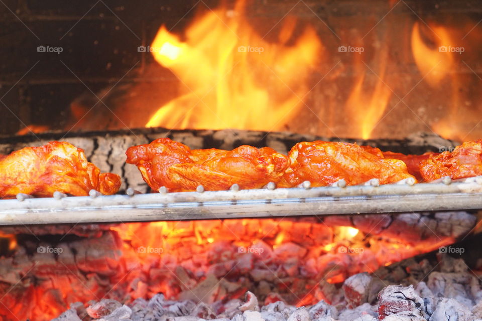Close-up of coal with grilled chicken