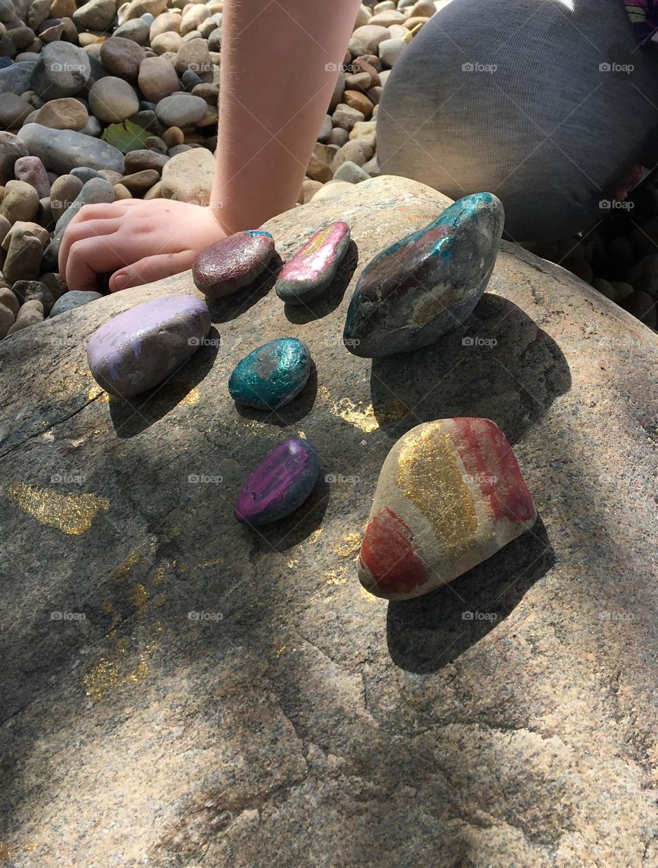Young girl shows off her little painted rock collection that she found at the beach