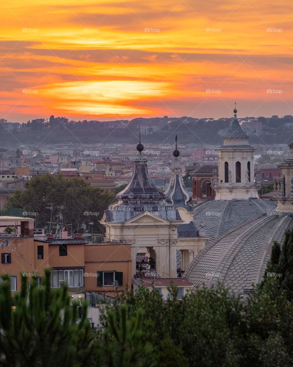 Beautiful sunset over tall steeples and domes in Rome Italy