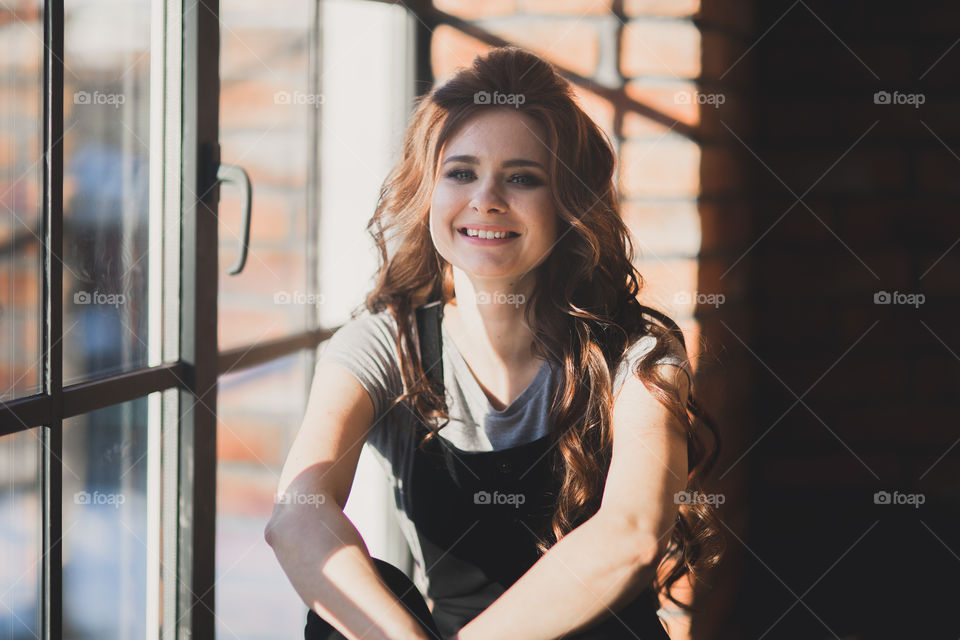 Portrait of young beautiful woman near window