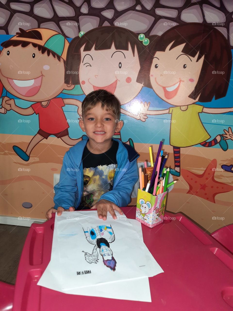 beautiful child coloring the super hero at school