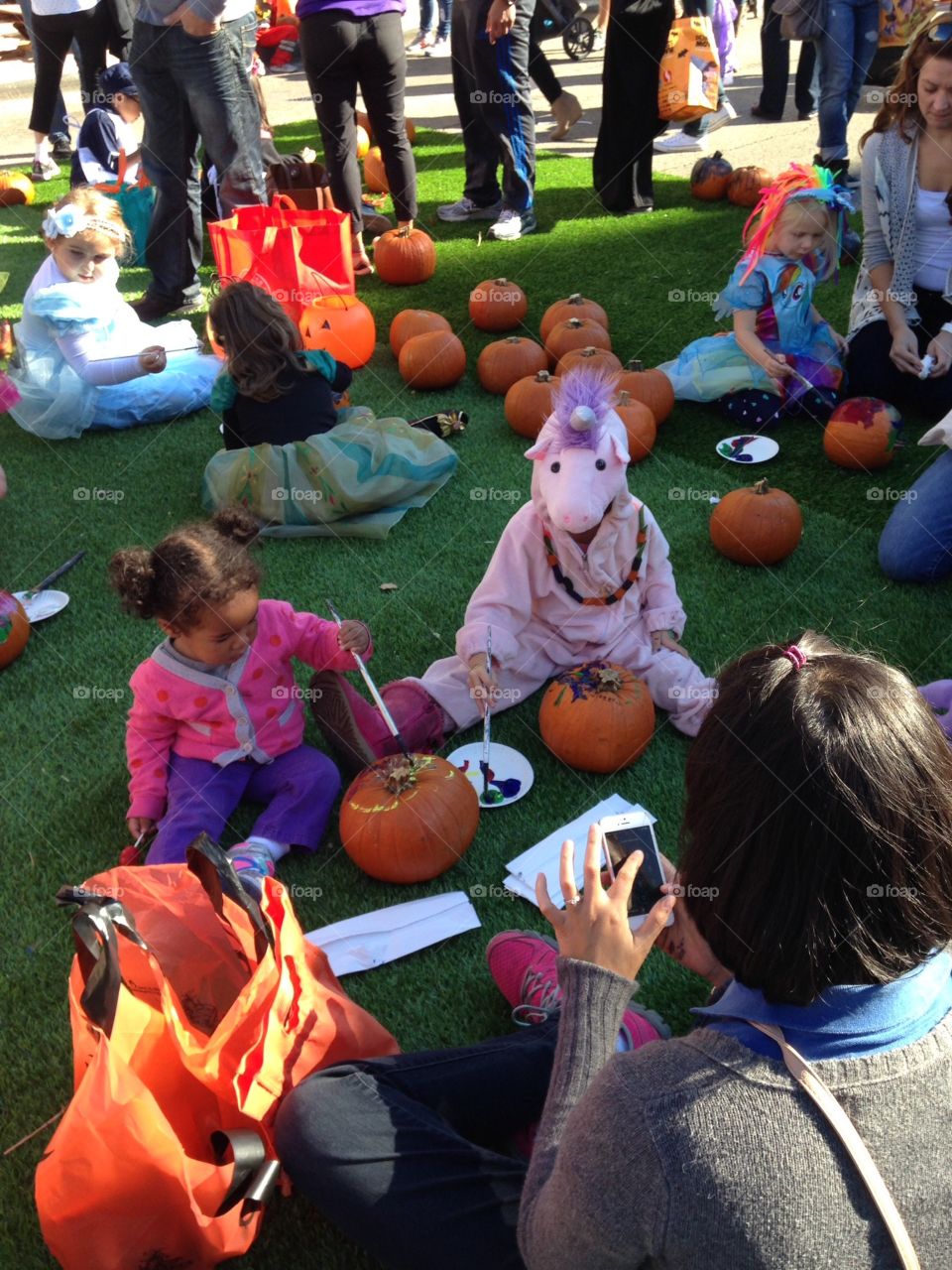 Kids painting pumpkins. Halloween festival