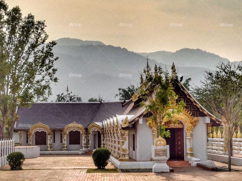 Buddhist temple with mountains background in Chiangmai ,Thailand 