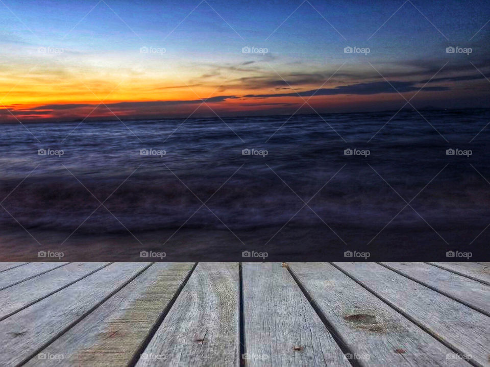 Sunset view with seascape and wooden decor table for display products. 