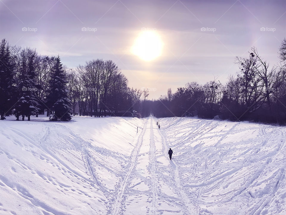 Sunset with a halo during the winter solstice over the covered by white snow land 