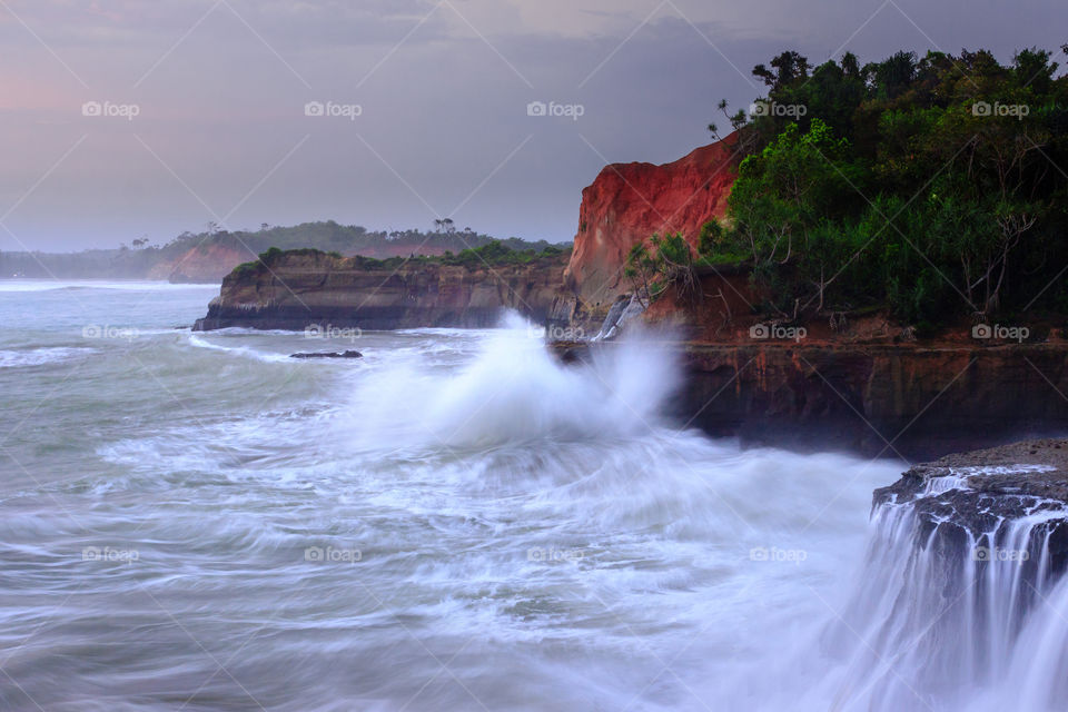 splashing waves on the beach with high cliffs
