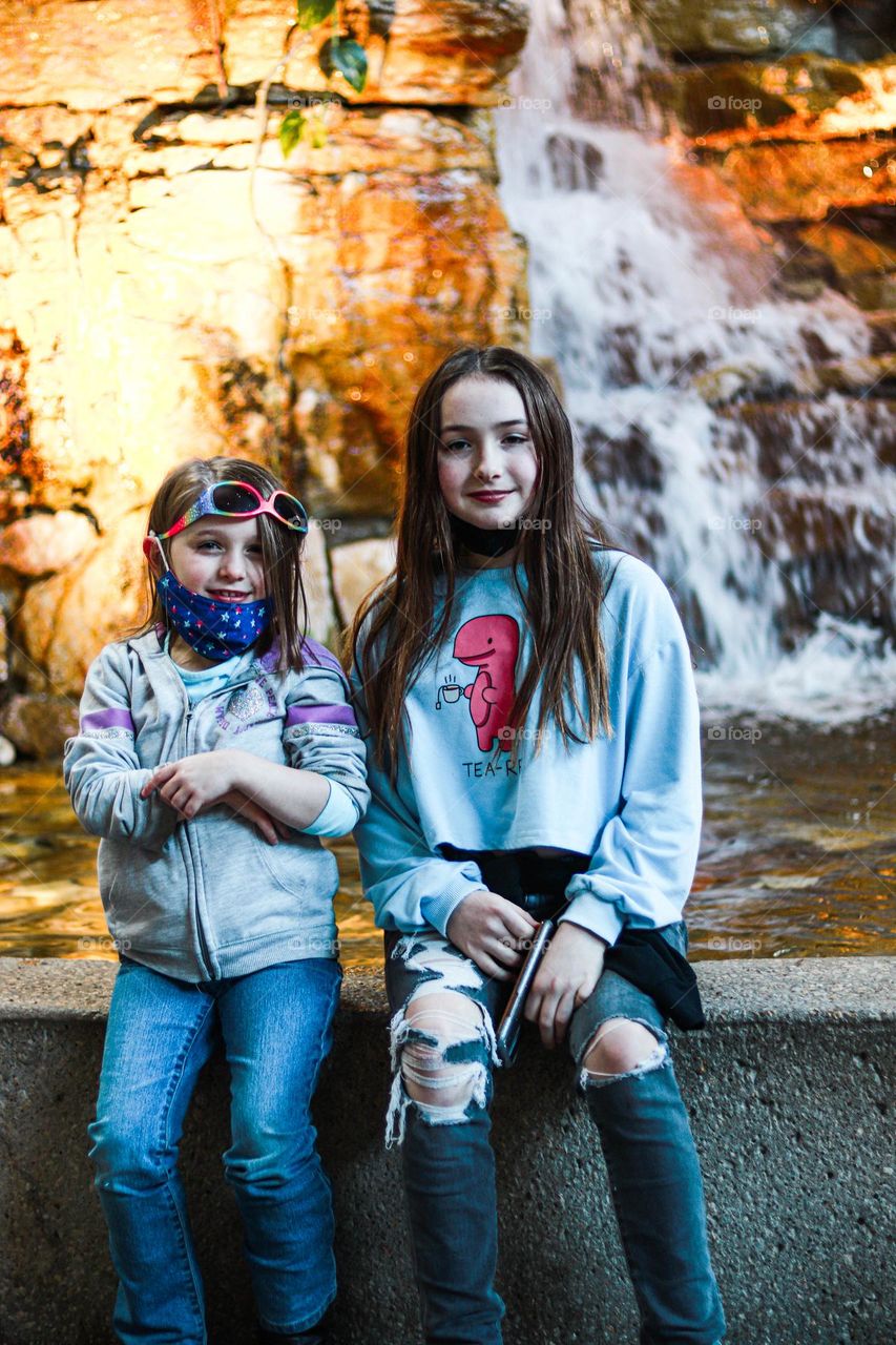sisters by a waterfall