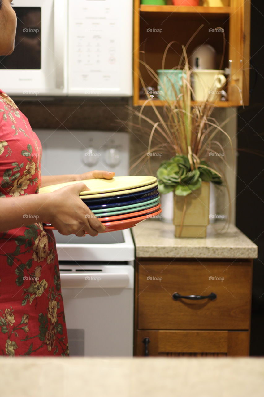 handy woman arranging plates in her kitchen 