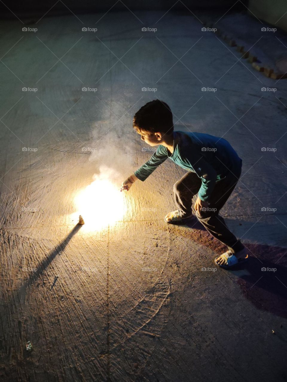 Diwali celebration with crackers and sweet,a boy fire cracker, night scene, slightly smoke