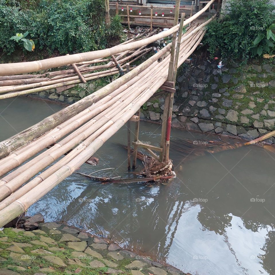 bamboo bridge over the river with clear water