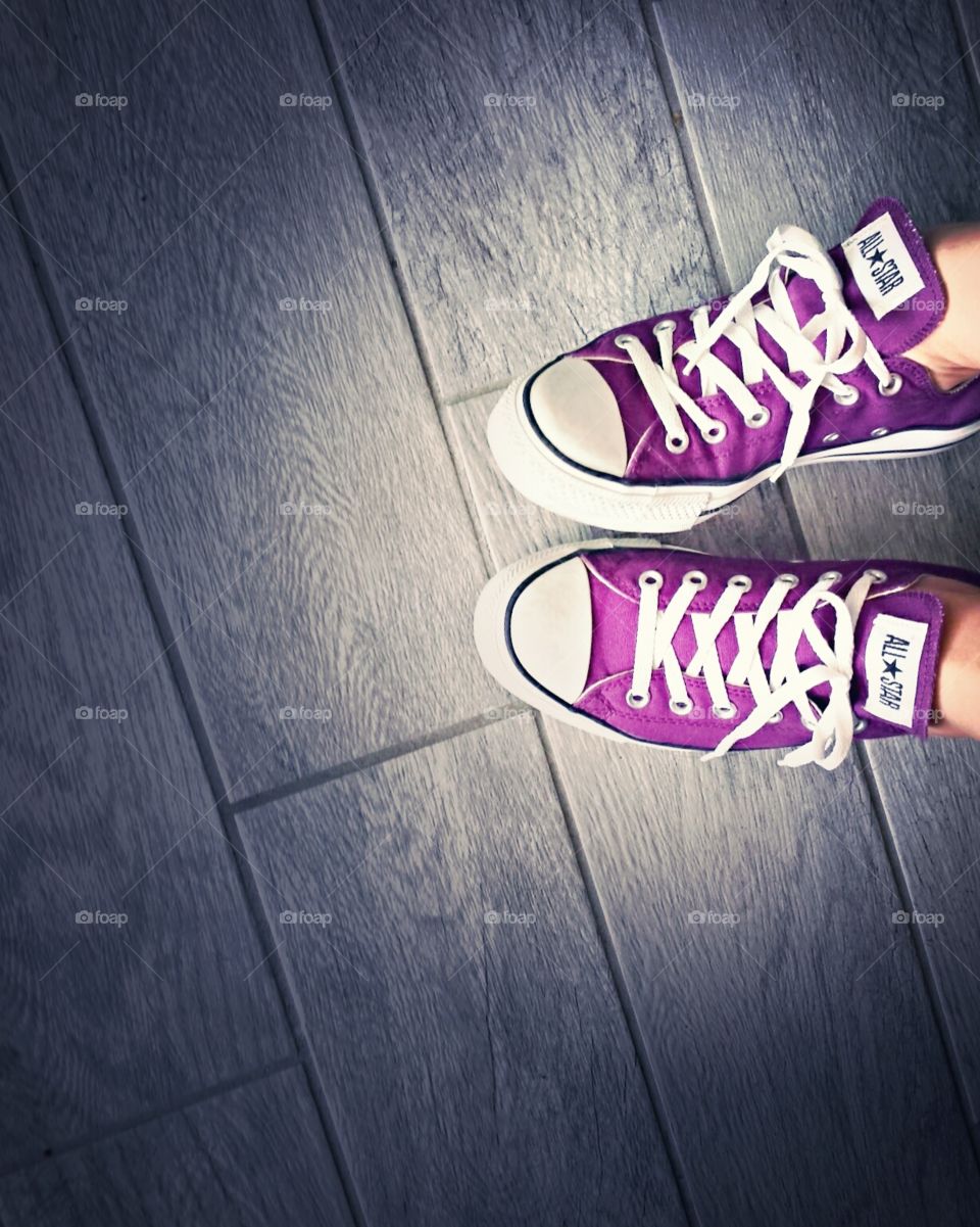Purple Converse Sneakers against grey floor