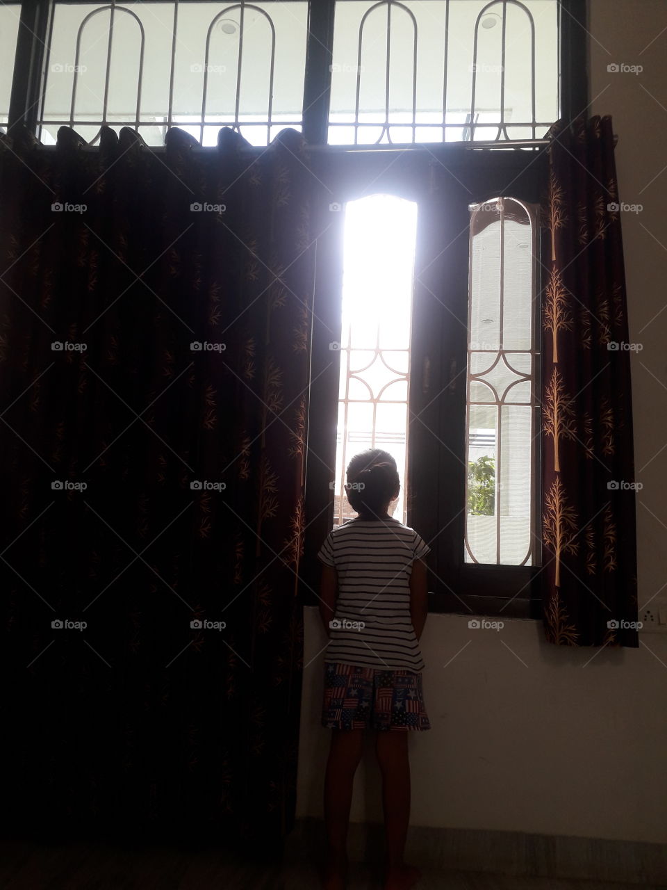 Child looking out the window during the day.
