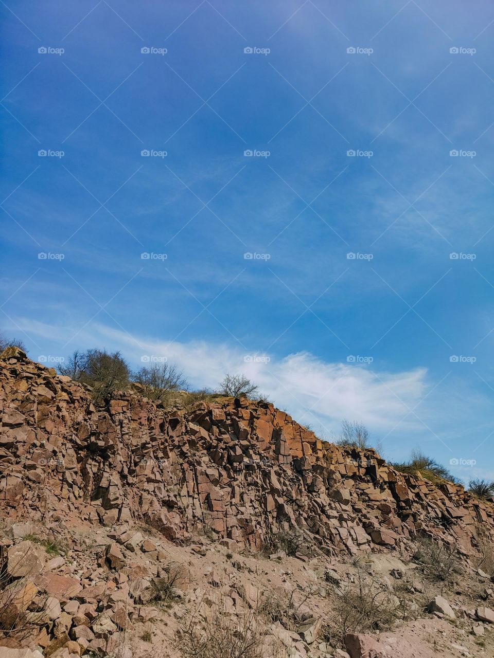 Rocks beneath the blue sky, sunny spring day landscape