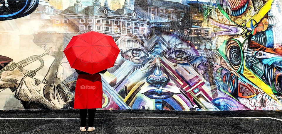 lady enjoying street art in the rain.