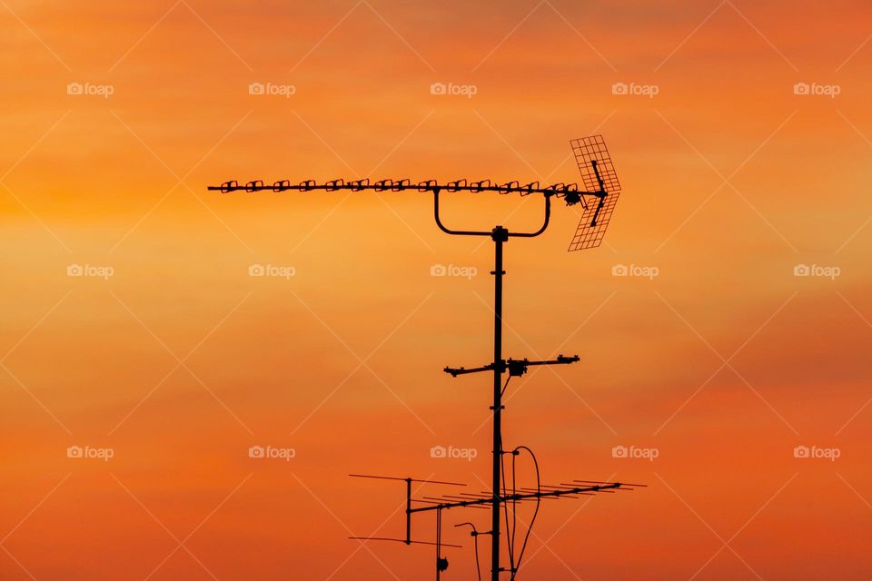 TV antenna against sunset sky