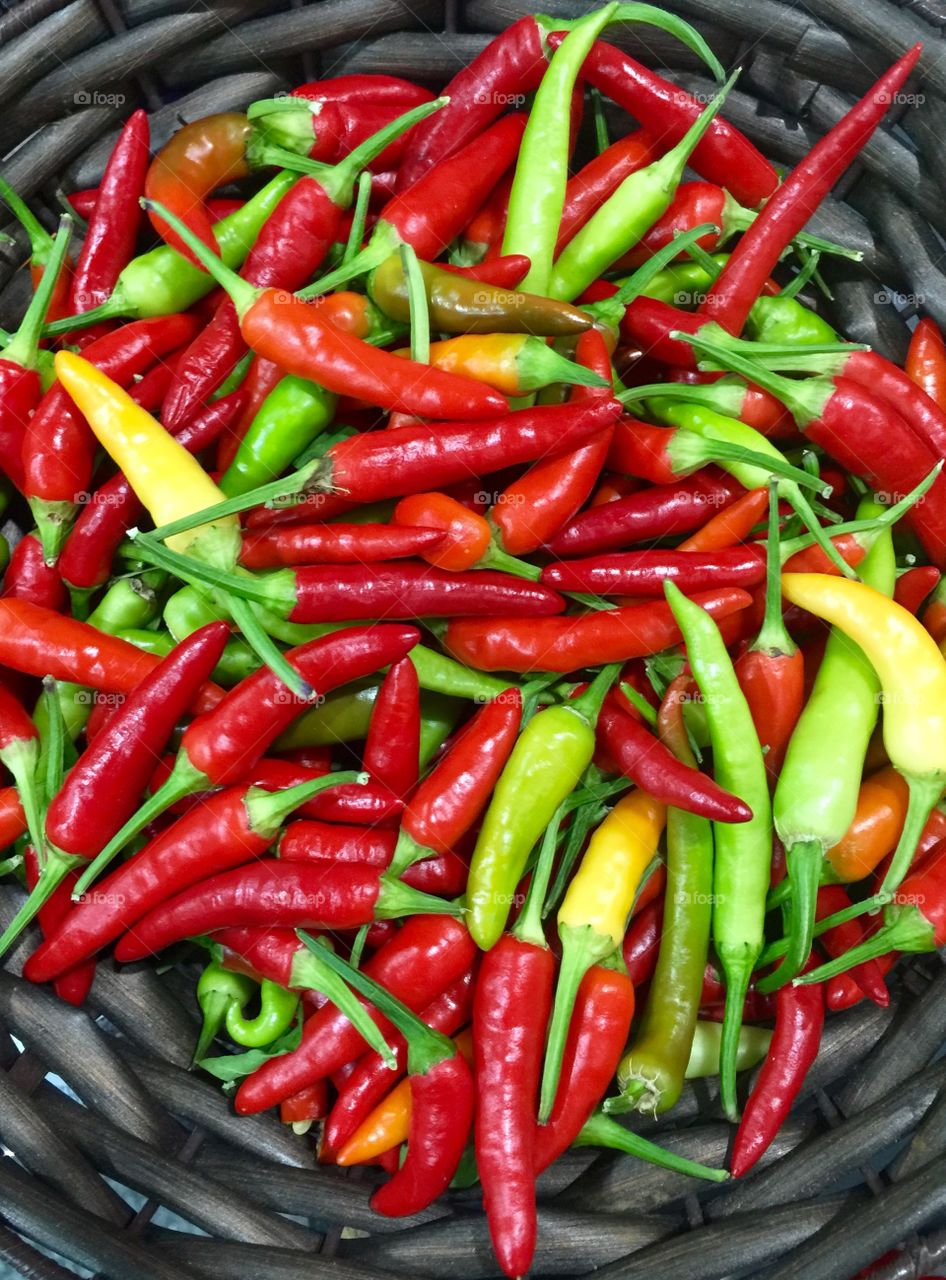 Green and red chillies in basket