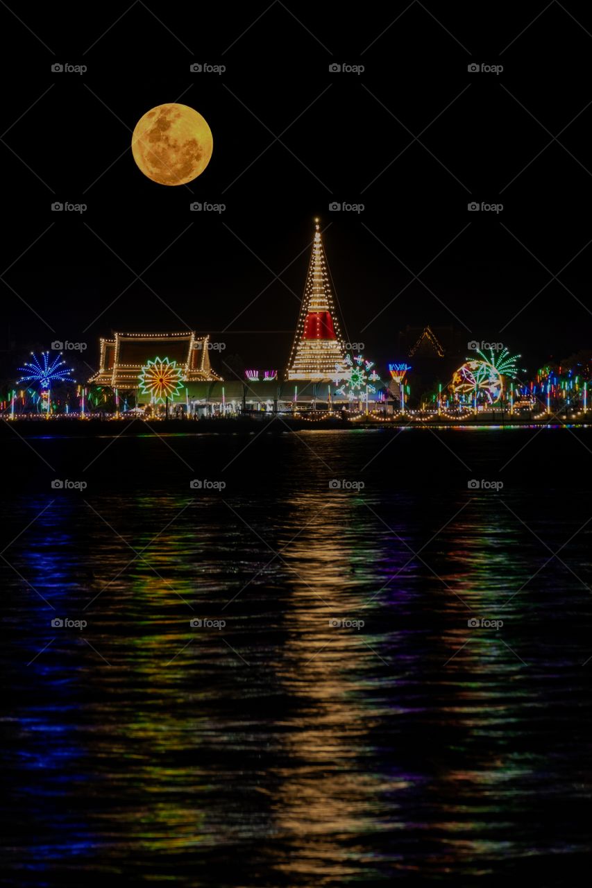 Beautiful light of Thai temple in front of full moon background