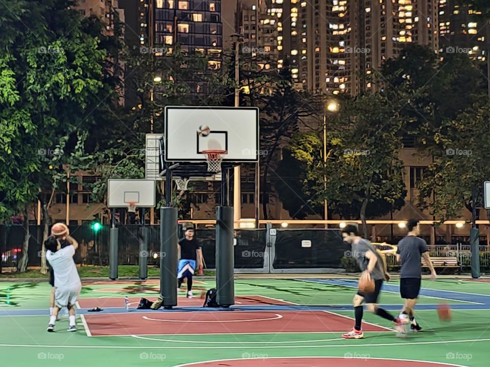 Men playing basketball after the rain Hong Kong at Victoria Park