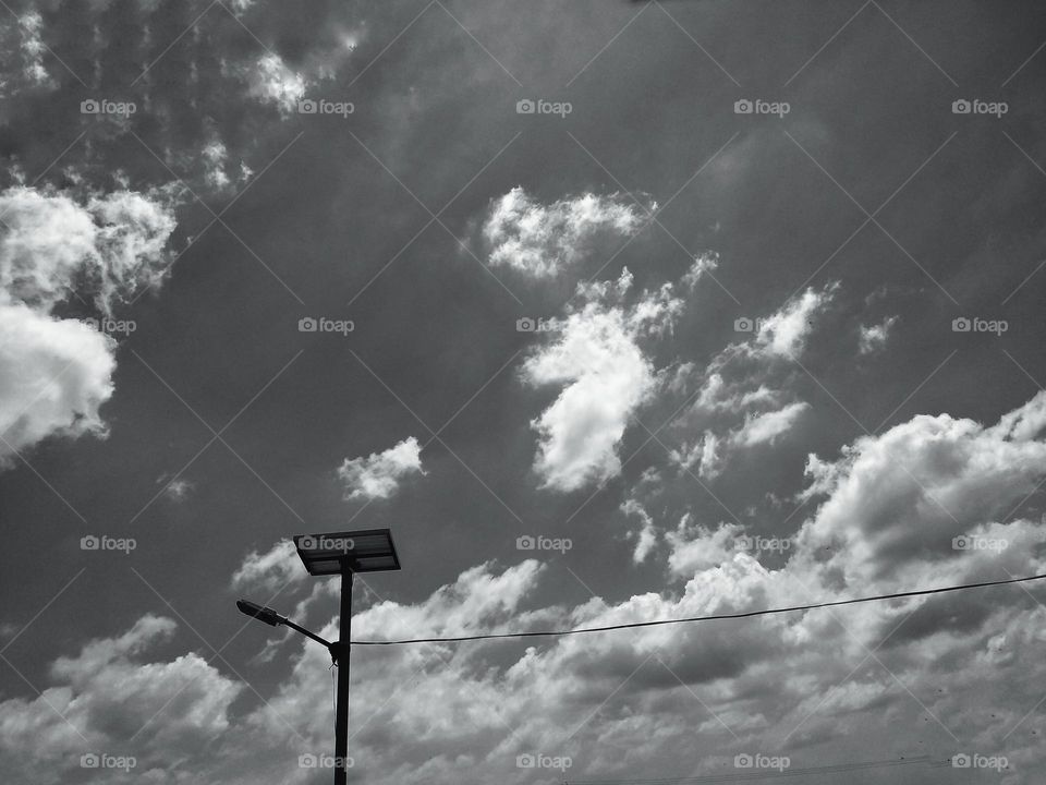 a lamp post against cloudy sky.