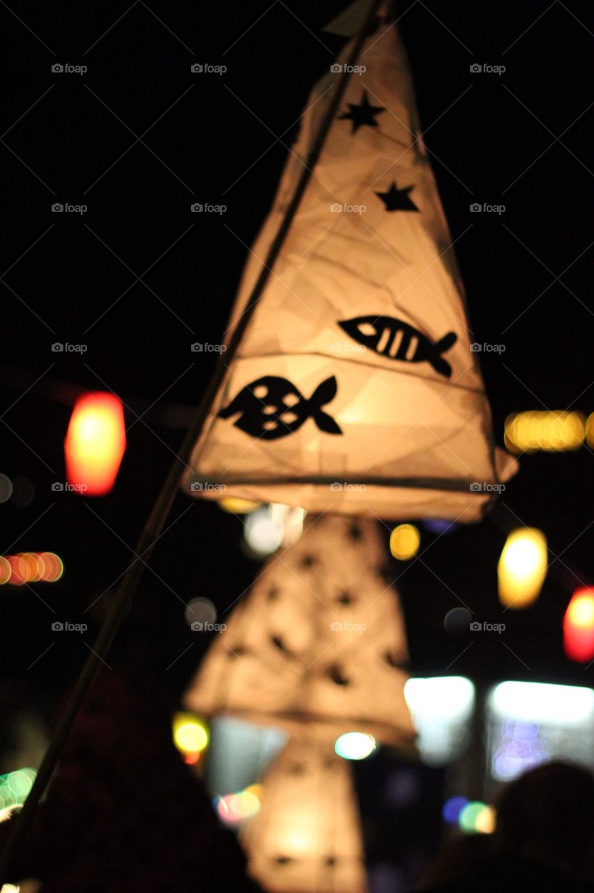 Lanterns lit up and being carried in a festival at night
