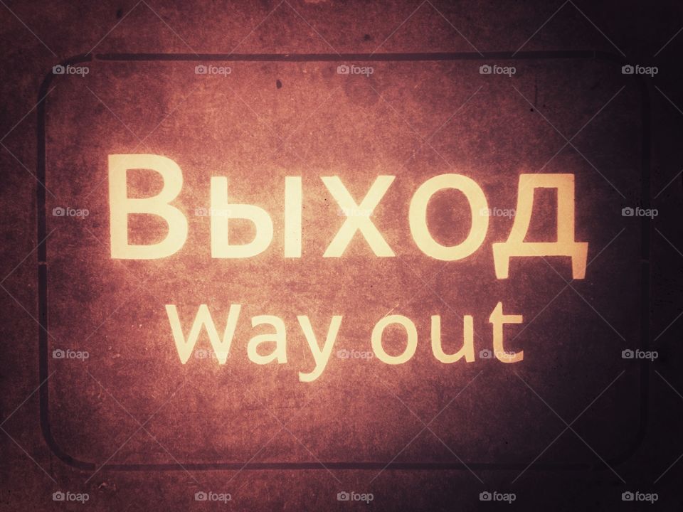 Yellow way out выход sign on the dark pink background