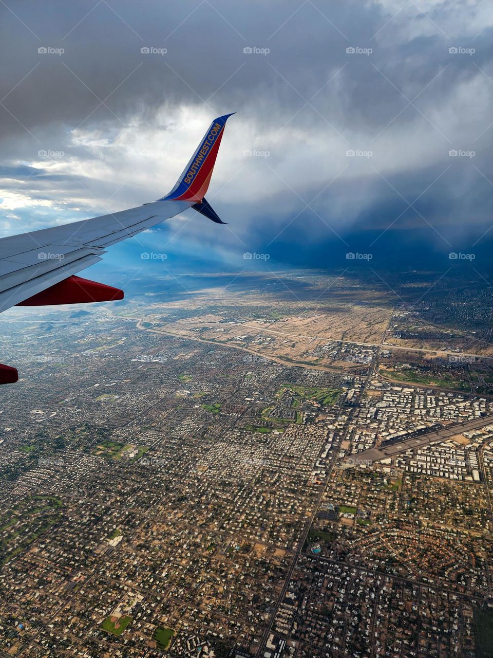 Flying in to Phoenix Sky Harbor International Airport during a summer monsoon storm illustrates many different weather types such as virga, rain shafts, and sunlight
