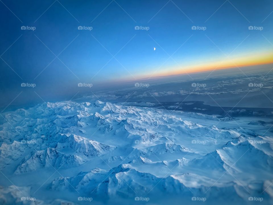 Aerial view of Alaska wintry mountains during sunset. 