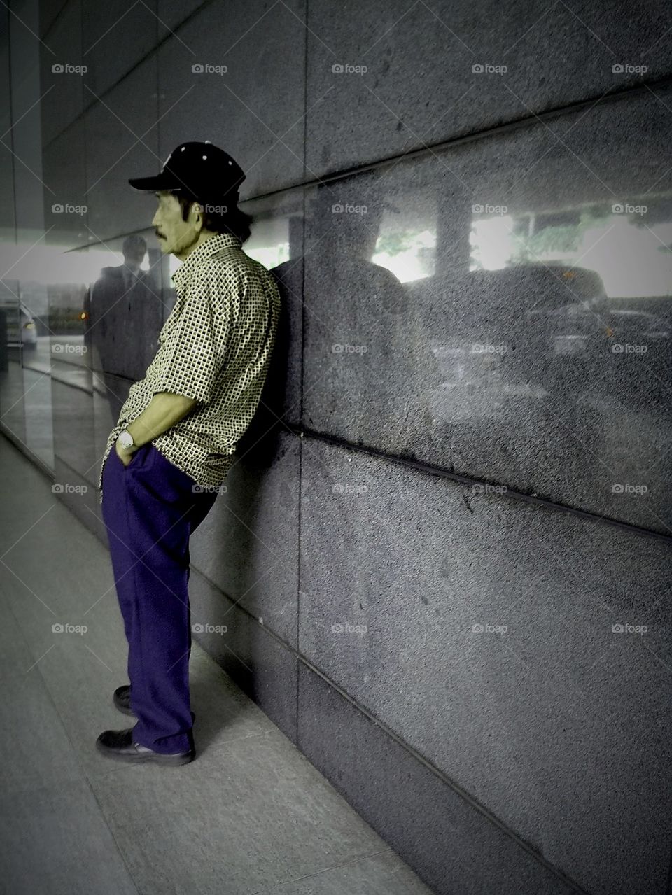 asian man leaning on a wall