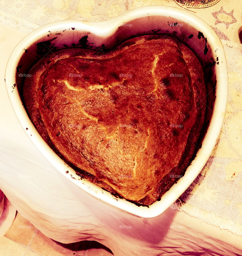 A freshly baked heart cake in a mold