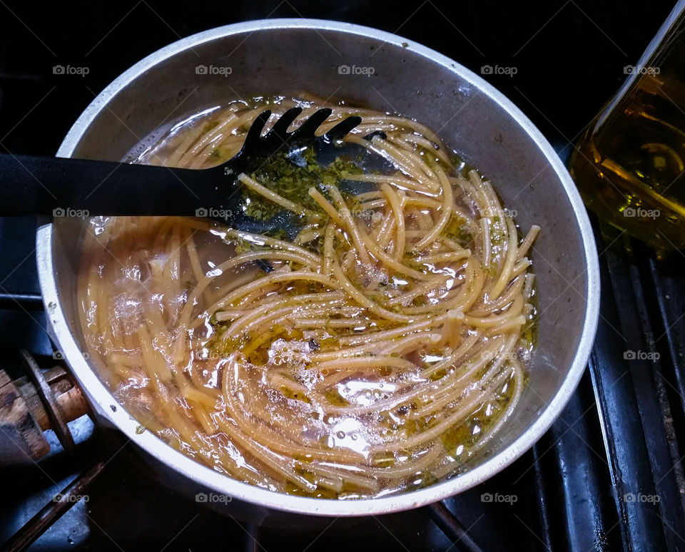 Cooking wholewheat spaghetti with olive oil and herbs