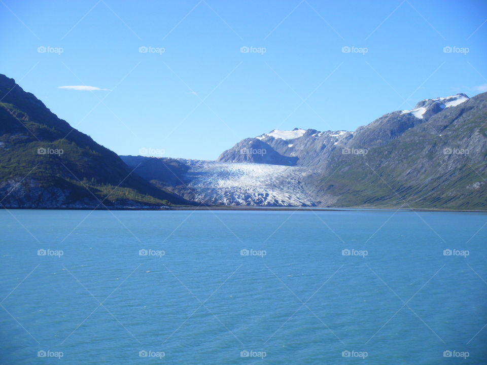 Mountain glacier and Blue Ocean view on clear sunny day from cruise ship in Alaska